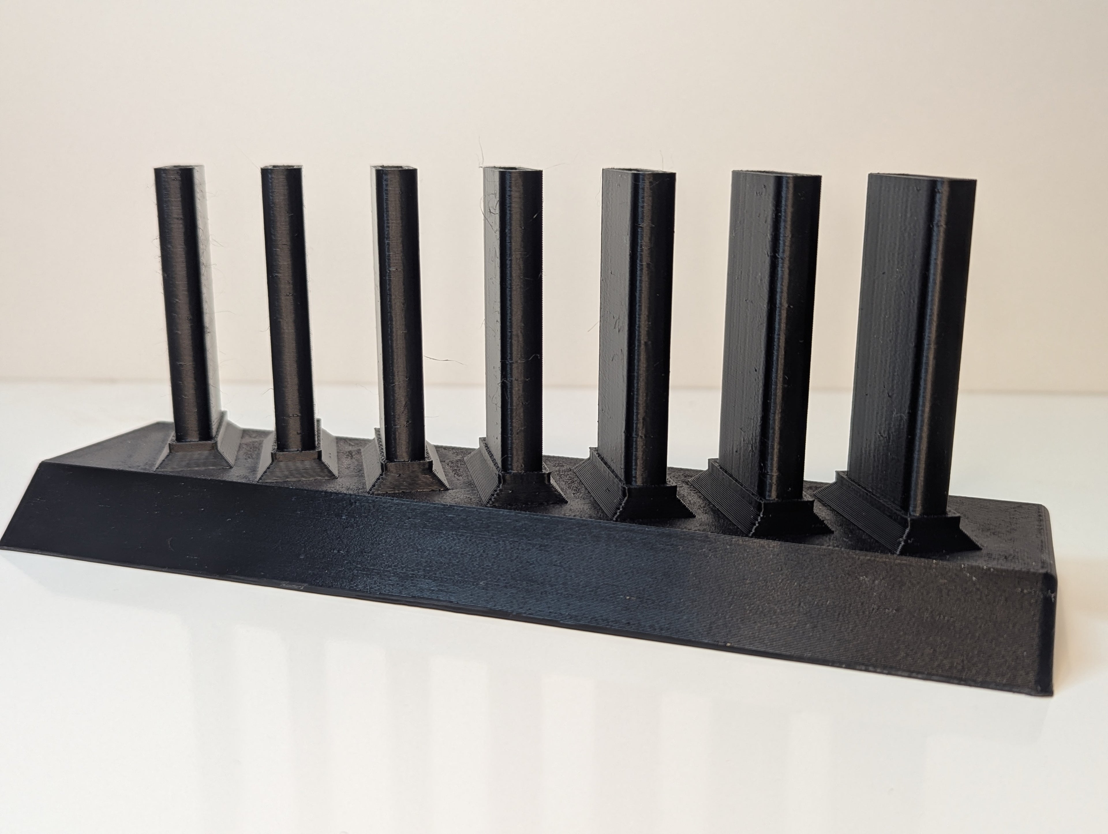 Sandpaper stick holder, currently empty, in black against a white background